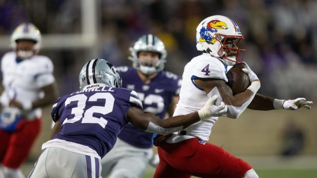 Kansas sophomore running back Devin Neal (4) runs through Kansas State redshirt freshman linebacker Desmond Purnell (32) during the first quarter of Saturday's Sunflower Showdown game at Bill Snyder Family Stadium.  